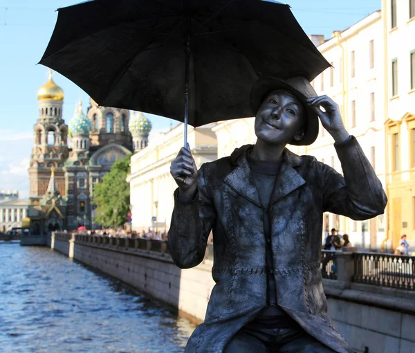 St. Petersburg, Rusya - 5 Temmuz 2014: Yaşam heykel bir çocuğun Griboyedov Canal, köprüden Savior dökülen kan üzerinde kilisenin arka plan üzerinde şemsiyesi ile — Stok fotoğraf