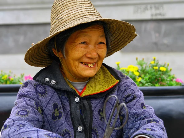 Wudanshan, Kina - 31 okt 2007: Leende äldre kinesisk kvinna i en stråhatt Royaltyfria Stockfoton
