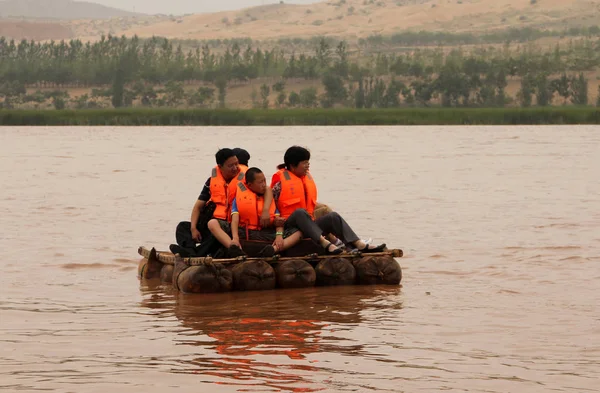 Ningxia, china - 9. Juli 2011: Touristen treiben auf einem Schaffell-Floß auf dem gelben Fluss (huang he). Luftballons dieser exotischen Floße, die von Einheimischen tatsächlich aus Schafsfell gefertigt wurden. Shapotou Tourismusgebiet — Stockfoto