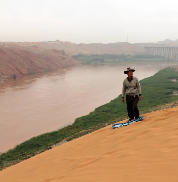 Нінся, Китай - 9 Лип 2011: Китаєць буде ковзати вниз пагорб піску в банку Хуанхе (Хуан He). Пісок розсувні є популярною туристичною визначною пам'яткою в районі Shapotou — стокове фото