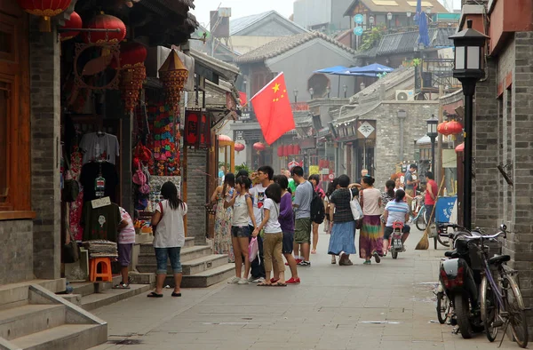 BEIJING, CHINA - JUL 4, 2011: Tourists walking at Yandan (Pipe) hutong. This ancient street is very popular tourist sight situated between Shichahai area and Drum Tower — Stock Photo, Image