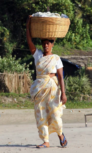 Goa, Indien-20 februari 2014: Indisk kvinna med stor korg på huvudet. I Indien, det är ett populärt sätt att få tunga saker — Stockfoto