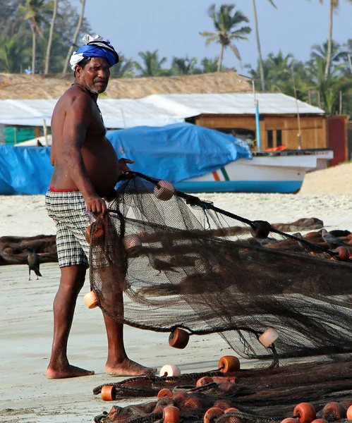 ГОА, Индия - 13 февраля 2014 года: Индийский рыбак тянет рыболовные сети. Рыбалка - ключевое занятие на побережье Индийского океана — стоковое фото