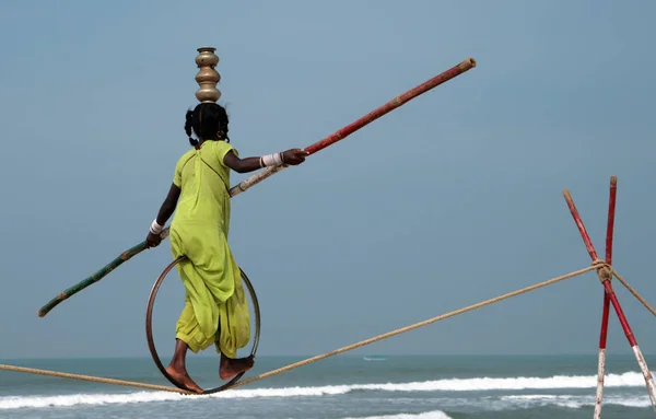 GOA, INDIA - FEB 12, 2008: Wandering tightrope walker playing on the beach. Small groups of buskers traveling along the coast and arrange free shows for tourists on the beach — Stock Photo, Image