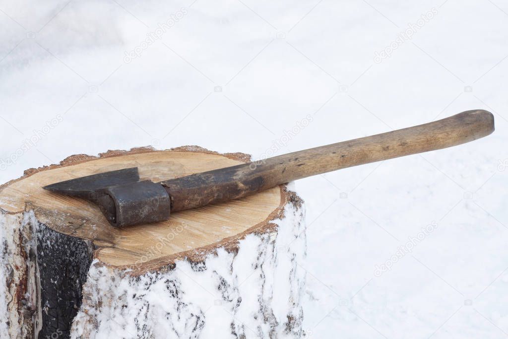 Big axe on a snowy stump