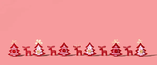 Рождественская Композиция Новогодние Рождественские Фигуры Оленей Перьев Стоят Розовом Фоне — стоковое фото