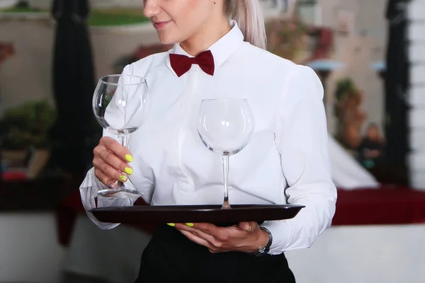 La chica la camarera trajo a los visitantes copas de vino. Foto sin rostro en el interior del restaurante . — Foto de Stock