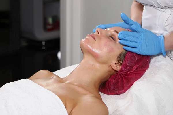 Estetista fa massaggio facciale in una clinica cosmetologica. concetto di bellezza e salute . — Foto Stock