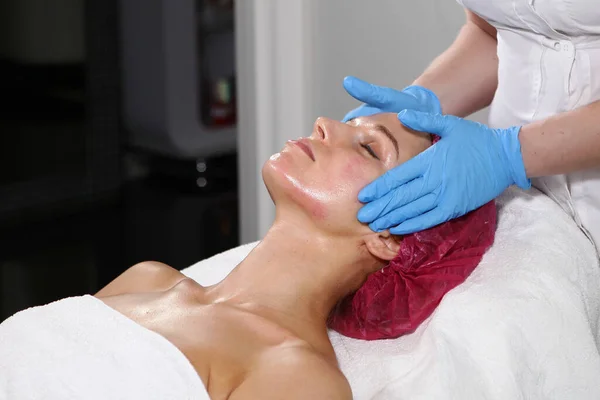 Masaje facial en una clínica de cosmetología. Concepto de belleza y salud . — Foto de Stock