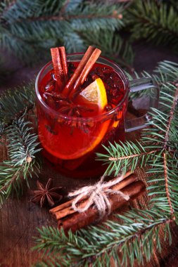 Ahşap zemin üzerinde tarçın olan sıcak kış çayı. Yakındaki firavun dalları ve mandalları. Yeni yıl ya da Noel tatili kavramı.