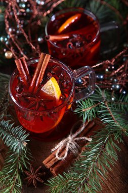 Ahşap zemin üzerinde tarçın olan sıcak kış çayı. Yakındaki firavun dalları ve mandalları. Yeni yıl ya da Noel tatili kavramı.