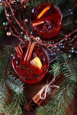 Ahşap zemin üzerinde tarçın olan sıcak kış çayı. Yakındaki firavun dalları ve mandalları. Yeni yıl ya da Noel tatili kavramı.