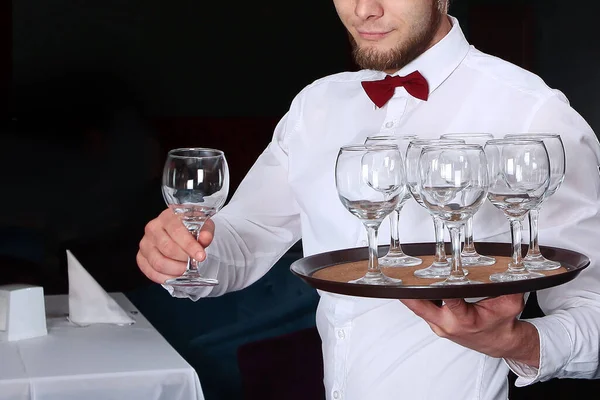 Un joven camarero sirve copas de vino. Foto sin rostro en el interior del restaurante . — Foto de Stock