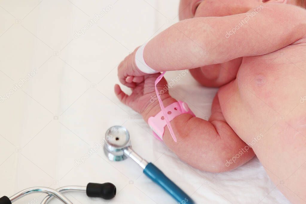 Macro photo of a newborn baby's pens and medical supplies on a white background. The concept of saving children's lives. The work of doctors. Photo without a face. in room. View from above.