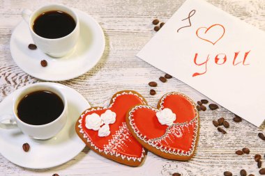 Kurabiyeler tatil için kalp şeklinde yapılır. Sevgililer Günü. Aşk, rahatlık, ruh hali, dilekler. Yazıt talebi için parça. Bir fincan kahve..
