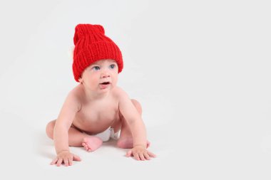 Kırmızı şapkalı bebek ve beyaz arka planda bebek bezi. Boş sp
