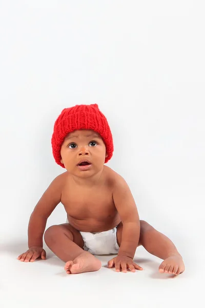 Bambina con un cappello rosso su sfondo bianco. Concetto di Capodanno. Copia spazio oggetto isolato.Macro foto . — Foto Stock