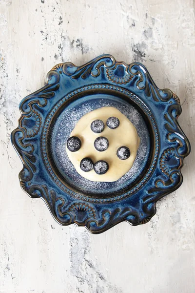 Pancake with vanilla sauce and blueberries on a blue ceramic plate. View from above. The concept of delicious and healthy breakfasts. — Stock Photo, Image