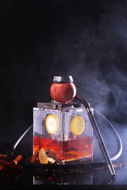 Hookah with a square flask based on tea. Tea and lemon in a transparent flask of a hookah.