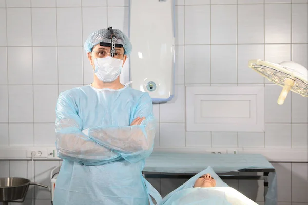 Dentist surgeon in the operating room with binocular glasses. Doctor and patient at the dental clinic before surgery. — Stock fotografie