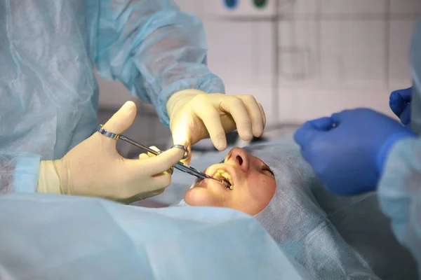 Close-up hands of a dentist surgeon doing anesthesia to a patient. Macro photo in the operating room. — Stock fotografie