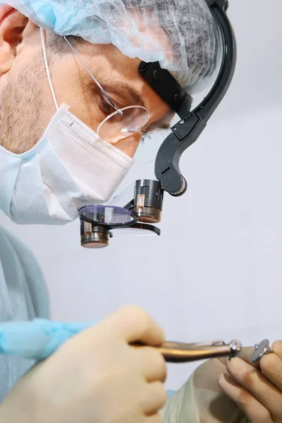 Închiderea unui chirurg dentist se confruntă cu un microscop în ochelari. Ochelari binoculari. Macro fotografie . — Fotografie, imagine de stoc