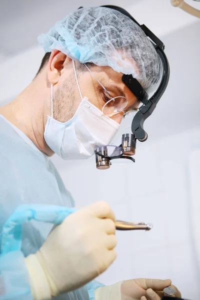 Close-up of a dentist surgeons face with a microscope in glasses. Binocular glasses. Macro photo. — Stock fotografie