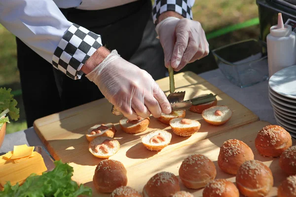 Catering service in nature. Cook's hands make sandwiches. Concept of catering and corporate parties.
