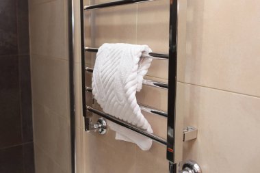 Banyodaki havlu korkuluğuna beyaz bir ayak havlusu asılmış. Otel işi ve eğlence anlayışı. Banyoda rahatlık ve temizlik. Uzayı kopyala Yukarıdan görünüşü