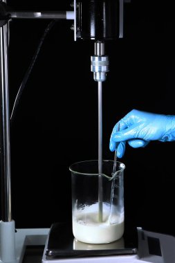 Laboratuvarda, yeni kremin bileşenleri karışıyor. Tanımlanamayan fotoğraf. Boşluğu kopyala.