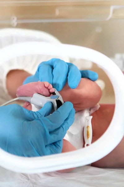 在重症监护下的新生儿 拯救生命的概念 医生的手和婴儿的脚的特写 照片在医疗车里 — 图库照片