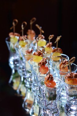 Bayram masasında üzümlü ve cevizli kanepeler. Etkinlikler için yemek servisi. Karanlık bir arka planda fotoğraf. Boşluğu kopyala.