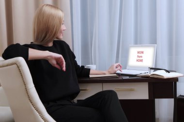 Evden bilgisayar başında çalışan bir kadın. Kendini izole etme ya da karantina modunda çalışıyor. Tanımlanamayan bir fotoğraf. Boşluğun kopyası.
