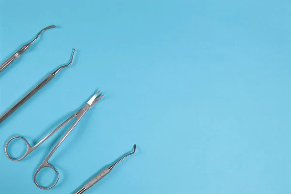 Ferramentas dentárias para tratamento dentário em um fundo azul . — Fotografia de Stock