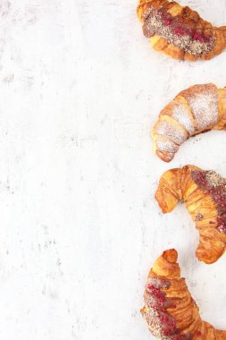 Açık dokulu arka planda dört kruvasan. Hafif bir arka planda pişirme. Üst Manzara. Boşluğu kopyala.