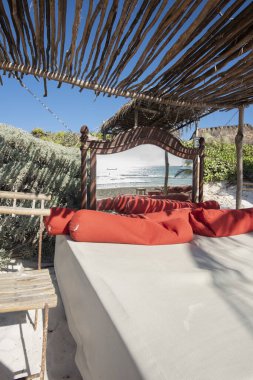 Sahilde deniz manzaralı ve panoramik aynalı büyük boy rahat bir yatak.