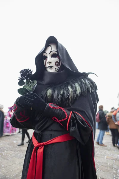 Venedik İtalya 'daki Karnaval Maskesi. Siyah bir gül tutarken 