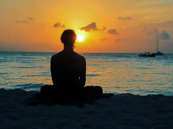 Gündoğumundaki genç kadın sahilde meditasyon yapıyor. Playa del Carmen Meksika Karayip Denizi. Yoga pozisyonunda bir kadın ve rahatla.