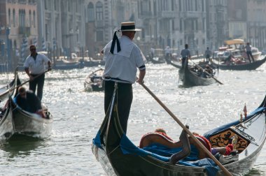 Rialto Köprüsü 'ndeki Venedik gondolları. Venedik 'teki Rialto köprüsü yakınlarındaki Gondol' lar, arka planda Büyük Kanal ve bu İtalyan şehrinin tipik antik binaları. Turizm ve seyahat kavramı