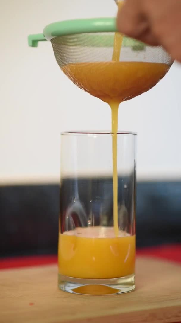 Mann Gießt Orangensaft Der Küche Seines Hauses Einen Glasbecher Nährstoffreicher — Stockvideo