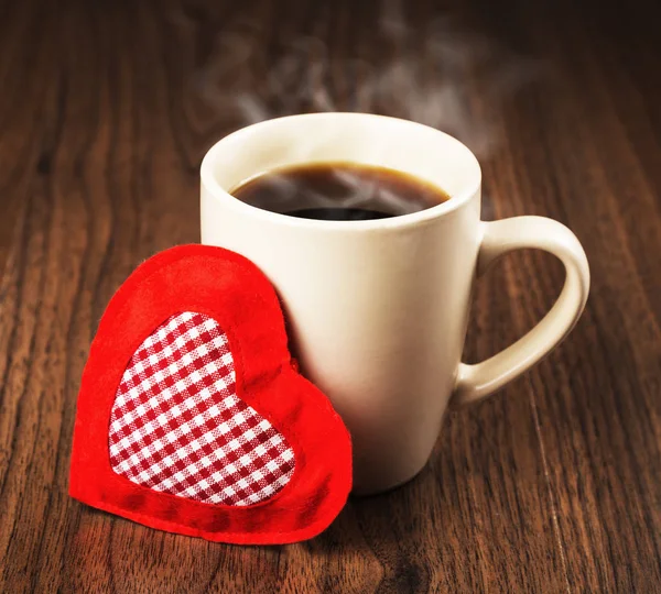 Gran taza de bebida caliente y corazón textil —  Fotos de Stock