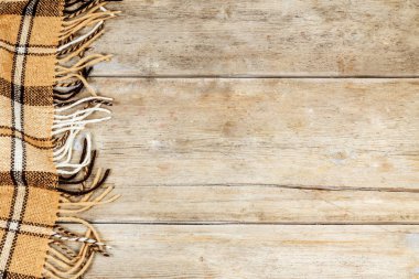 Bir ahşap yüzeyde damalı battaniye