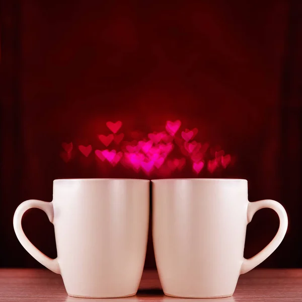 Deux tasses sur fond sombre avec bokeh . — Photo