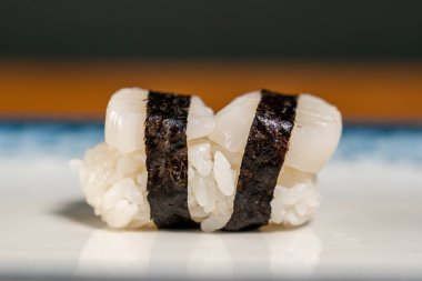 Arka planda bir tabakta suşi rulosu, kapat.