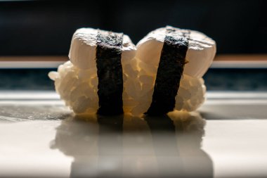 Arka planda bir tabakta suşi rulosu, kapat.