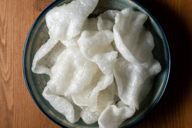 Arkaplanda bir tabak pirinç cipsi, yakın plan.