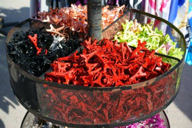 Eyfel Kulesi anahtarlıkları sepetin içinde farklı renklerde satılıyor. Açık hava, güneş ışığı.