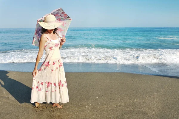 밀짚모자를 해변에 손에는 우산을 손에는 측면을 수평선 — 스톡 사진
