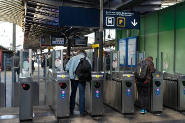 Paris-Est tren istasyonundaki bilet engellerini aşan insanlar banliyö trenlerinin platformlarına giriş izni veriyorlar. Gare de l 'Est, Paris, Fransa.