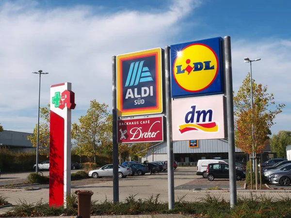 Aldi, Lidl, DM-Drogerie Markt ve mağazaların önünde bir eczane var. Almanya.
